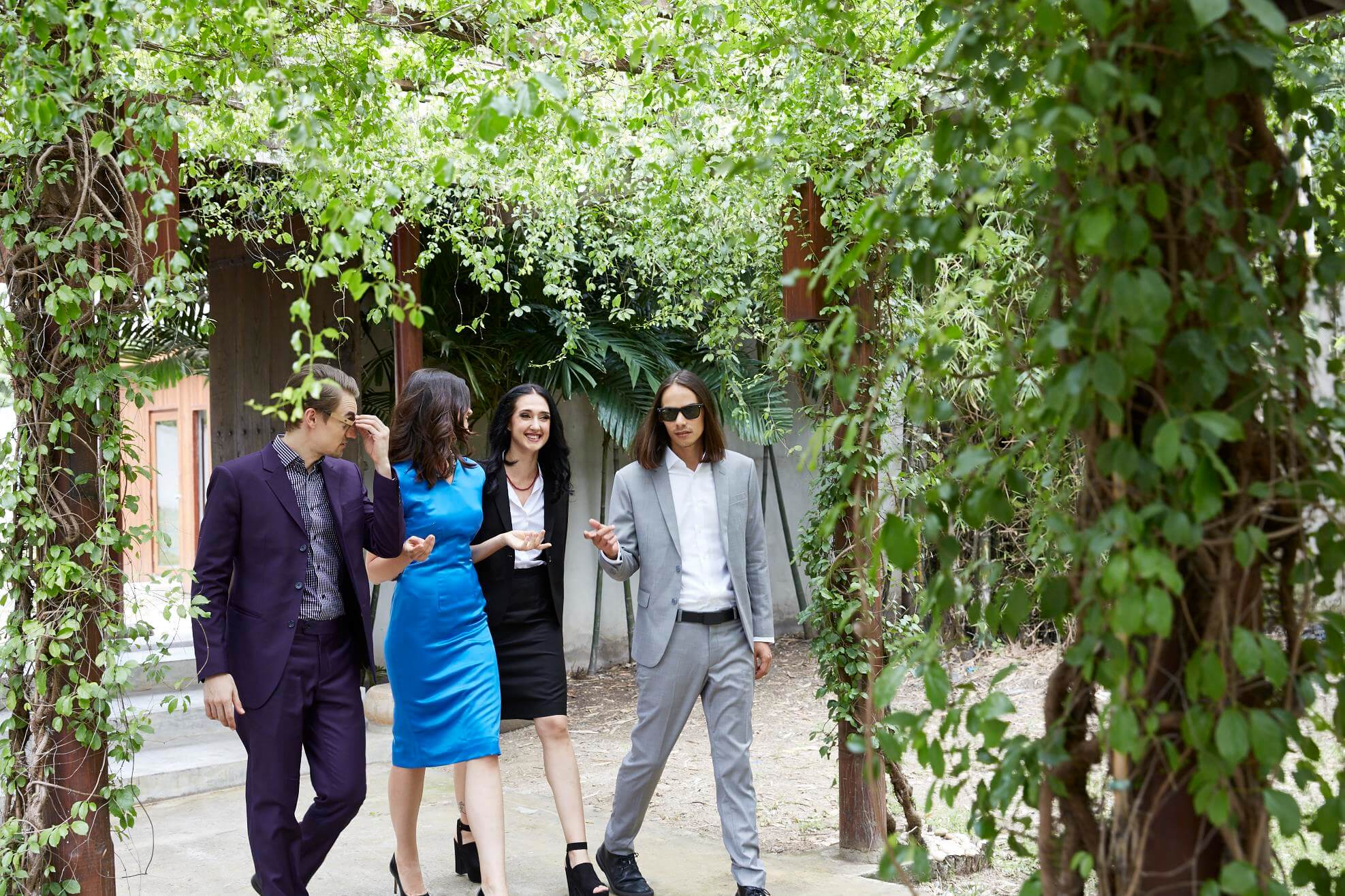 Two men and two women walking outside in their beautiful tailored clothes from Narry Bespoke.