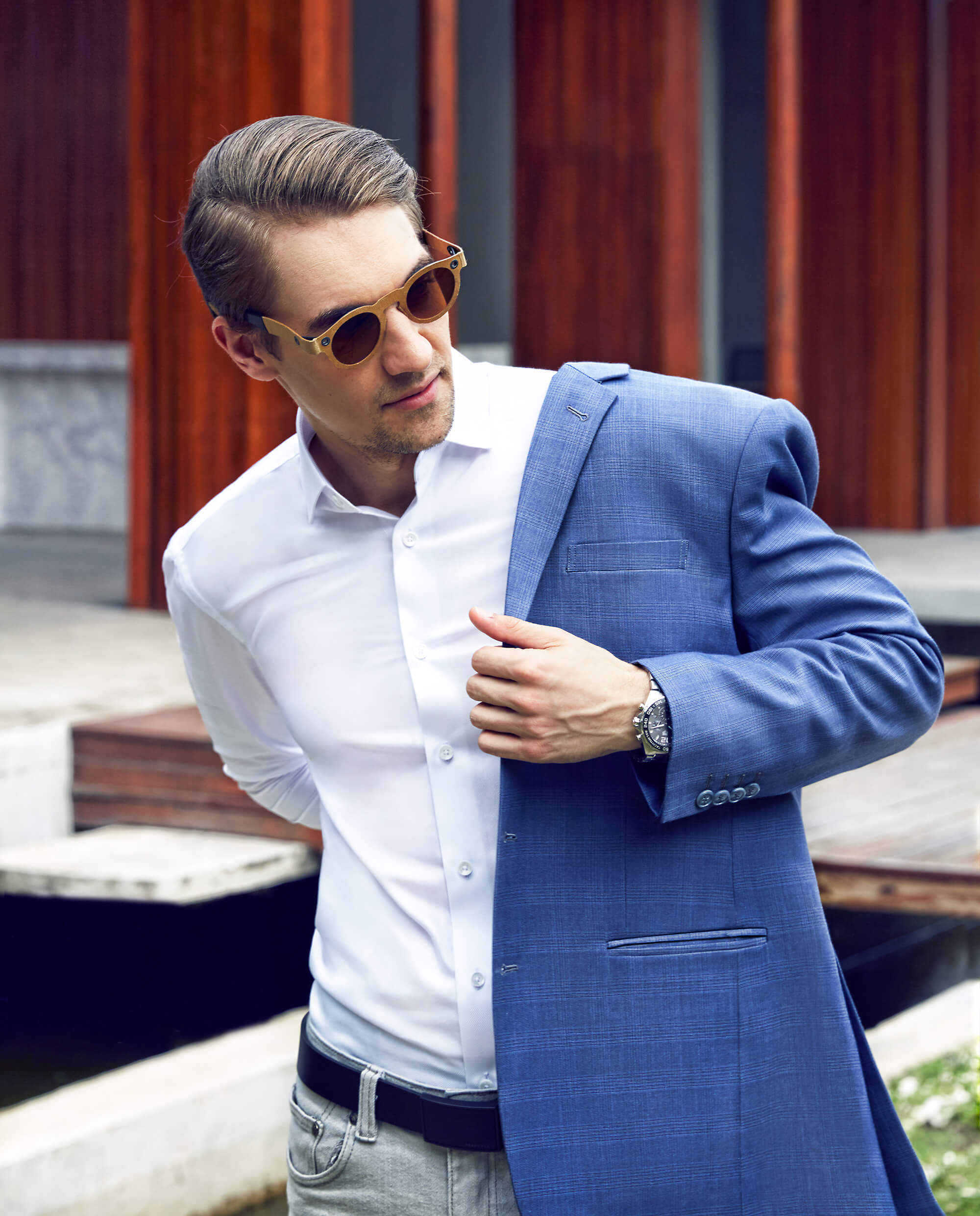 White man with sunglasses wearing a white shirt and a made to fit light blue jacket